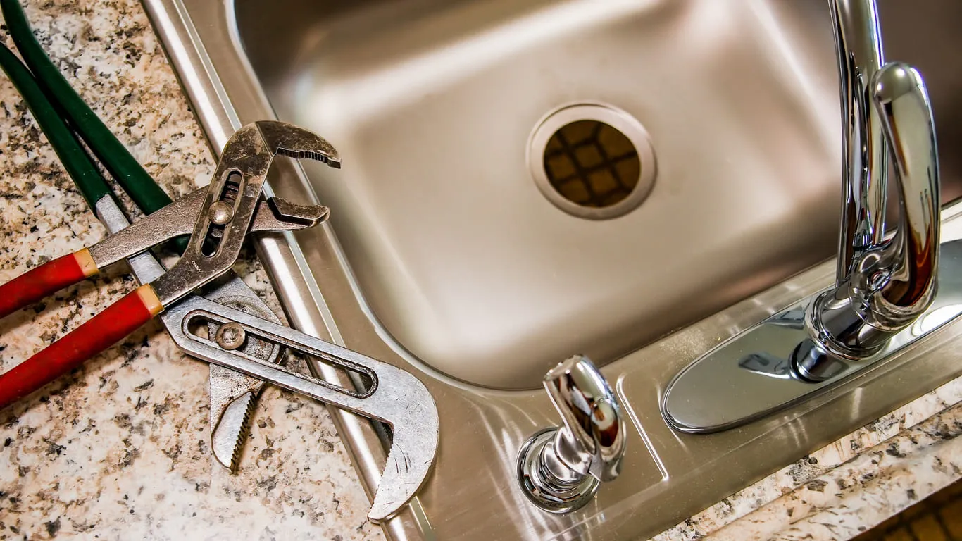 Plumber Fixing Kitchen Sink